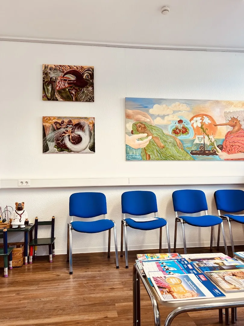 Wartezimmer der Praxis mit hellen Fenstern, Kunst an den Wänden und einer Kinderecke